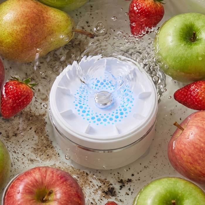 PuriEasy working at the bottom of a bowl of water with apples and strawberries around it